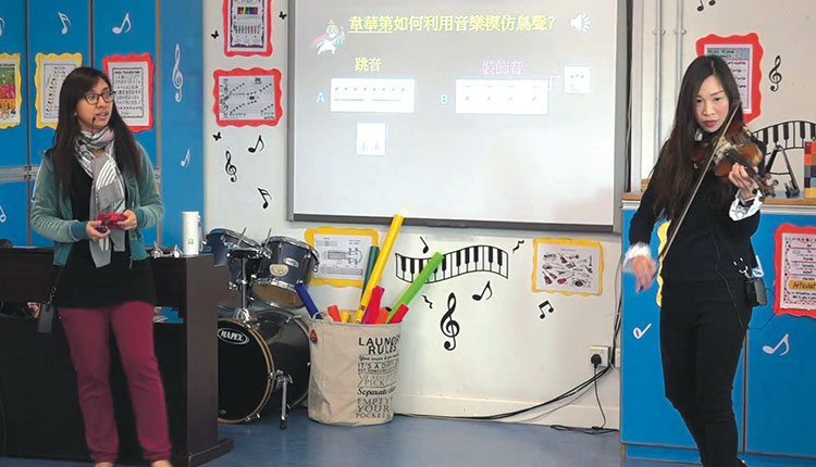 打鼓岭岭英公立学校：区恺心老师弹奏乐器，以此为楔子介绍经典名作。